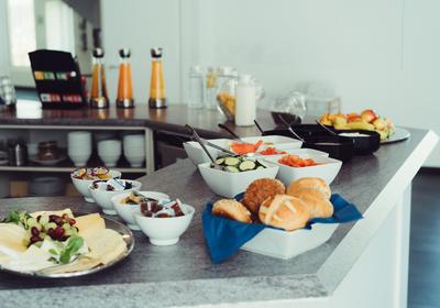 Frühstücksbuffet mit Käseplatte, Brötchen und Obst
